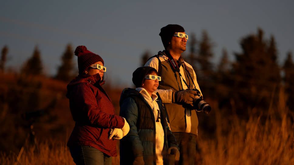 Люди наблюдают частное солнечное затмение в Галифаксе (Канада) .📷Фото: Darren Calabrese / The Canadian Press / AP