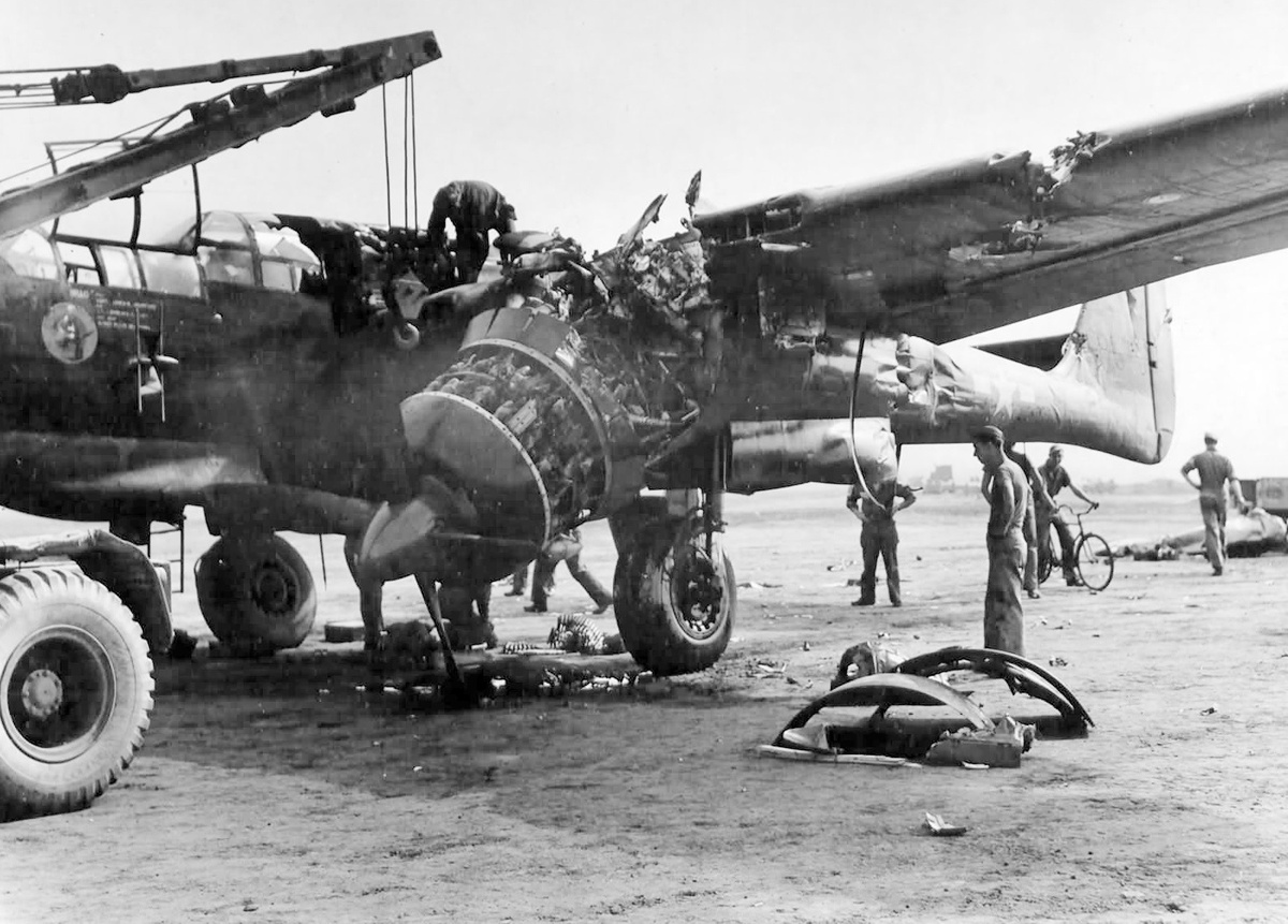 Ремонтники демонтируют левый двигатель самолета Р-61А-11, поврежденного при столкновении с истребителем Мелвина Боде.