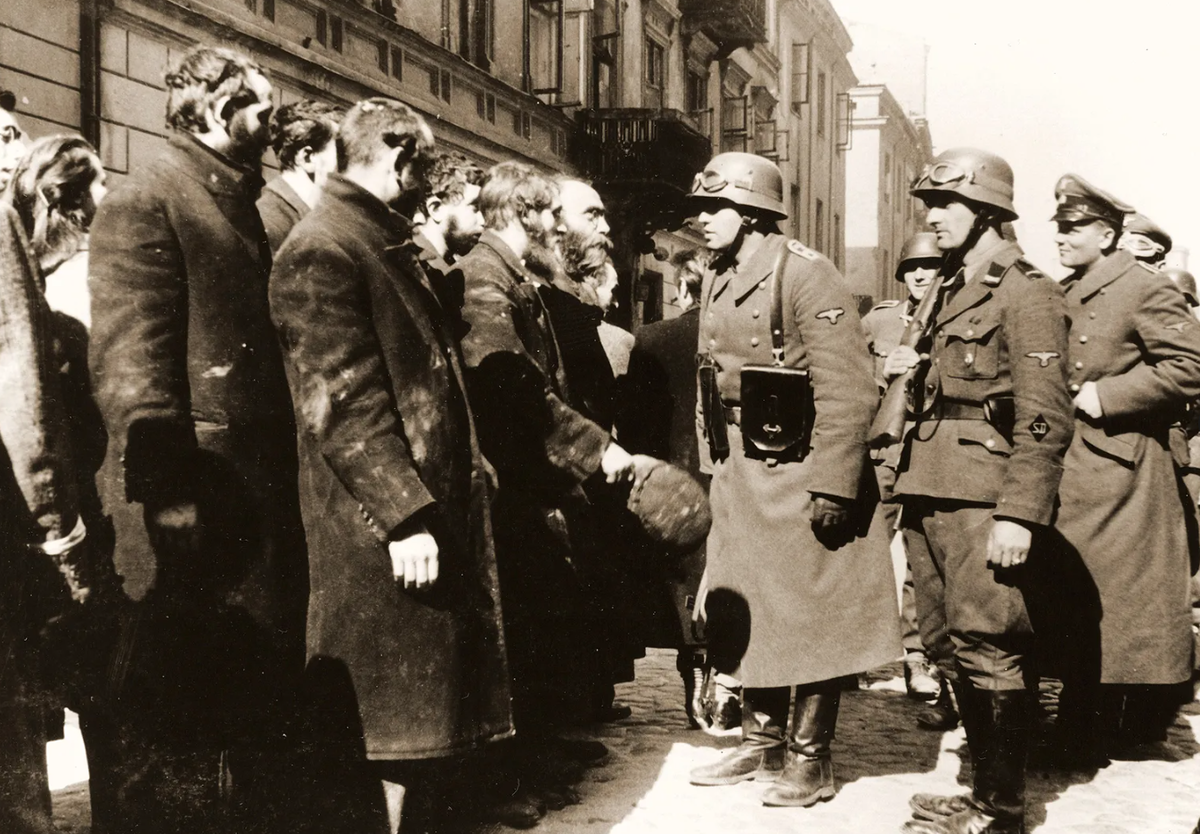 Восстание в Варшавском гетто. Сержант СС допрашивает евреев, захваченных во время подавления восстания.