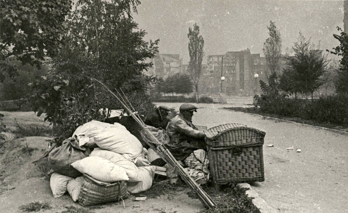 Сталинград. Жители города, оставшиеся без крова после очередной бомбёжки, в сквере города. Автор - Я. И. Рюмкин