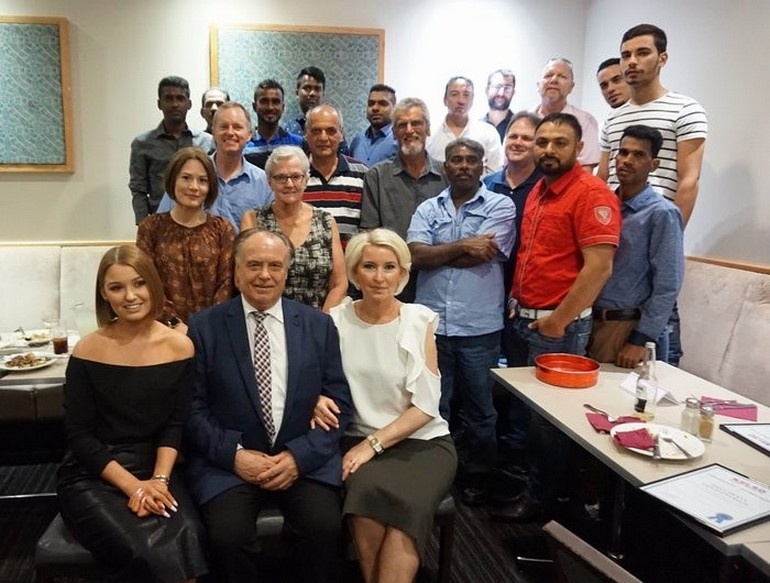 Михаил Овчинников с дочерью и женой, в окружении сотрудников его компании