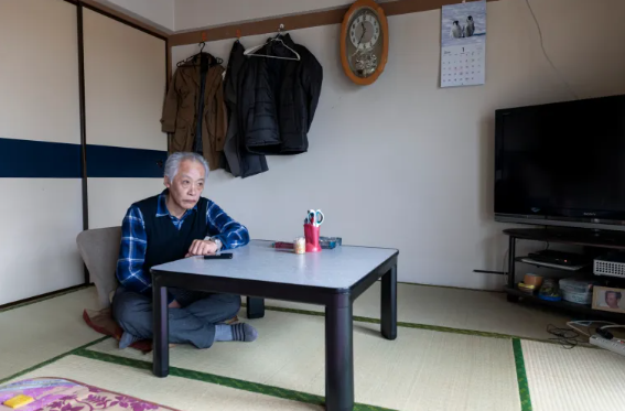 Пожилой дзайничи в своей японской квартире, похож на японца