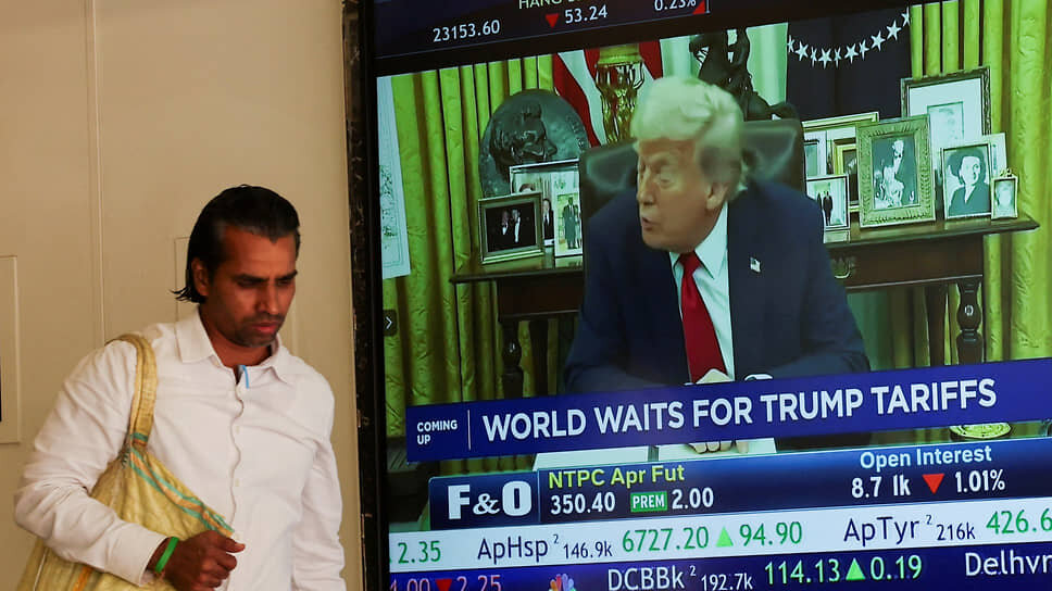 Мужчина рядом с экраном, на котором показывают Дональда Трампа.📷Фото: Francis Mascarenhas / Reuters