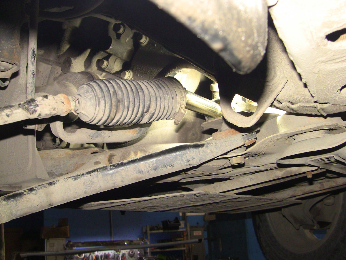 Сдвинутый влево пыльник обнажил вторичный вал рулевой рейки, показав следы износа в смазке.