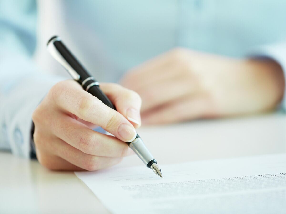    Девушка подписывает документы© Depositphotos.com / pressmaster