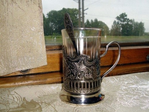 Стакан в подстаканнике на столике в купе вагона...