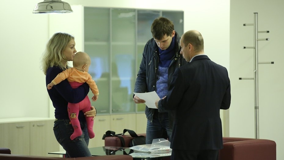    Молодая пара с ребёнком изучает документы перед покупкой жилья в ипотеку Автор фото: Пётр Ковалев / "Деловой Петербург"