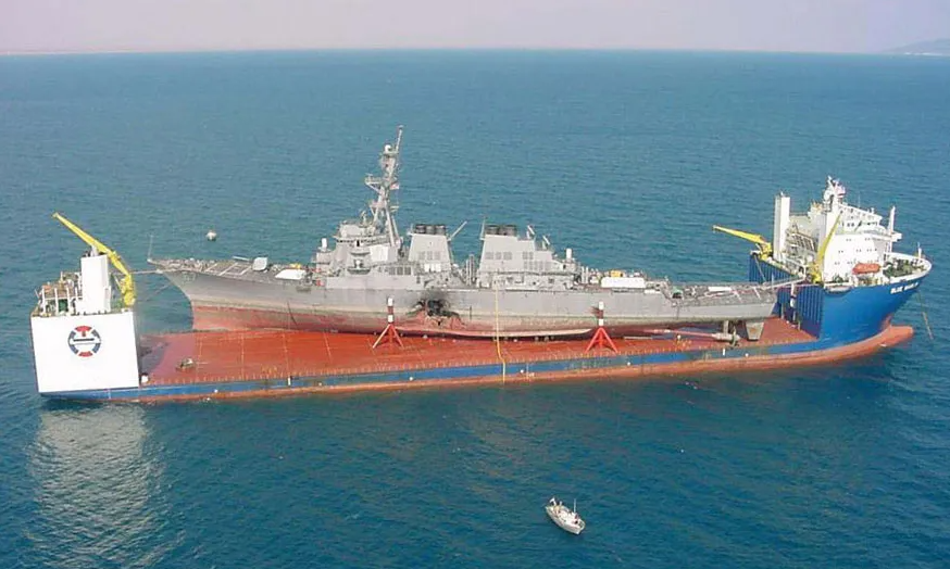 Атака USS Коул. USS Коул на борту транспортного судна MV Блю Марлин после нападения в гавани Адена, Йемен.