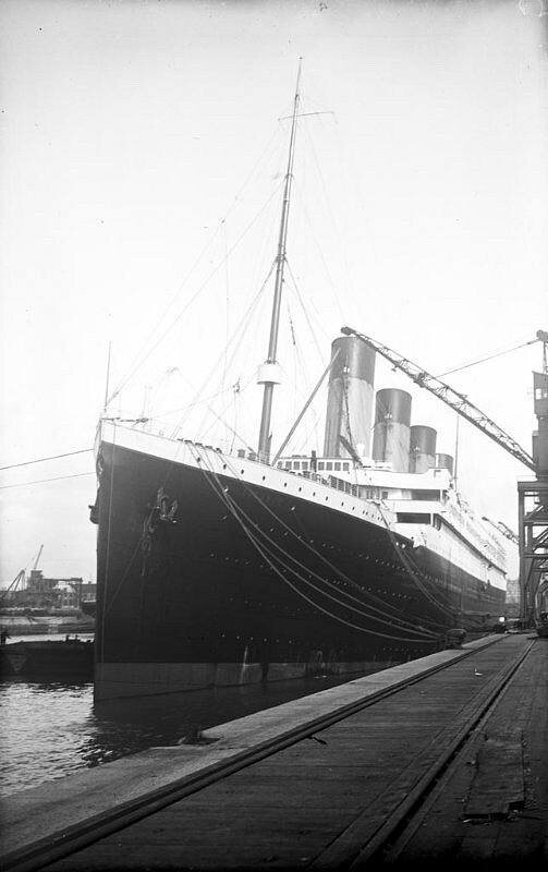 По правому борту «Титаника» стоят деревянные угольные баржи, готовые к погрузке угля.