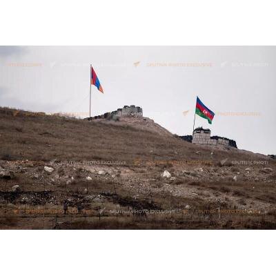 ЕЩЕ ДО ВЪЕЗДА В ХНАЦАХ, НА ПРИЛЕГАЮЩИХ ВЫСОТАХ, можно заметить азербайджанские флаги. Само село с несколькими сотнями жителей находится внизу и видно с тех позиций, как на ладони. Ближайший пост примерно в 330 метрах от села. А всего в нескольких метрах от него — позиция ВС Армении.