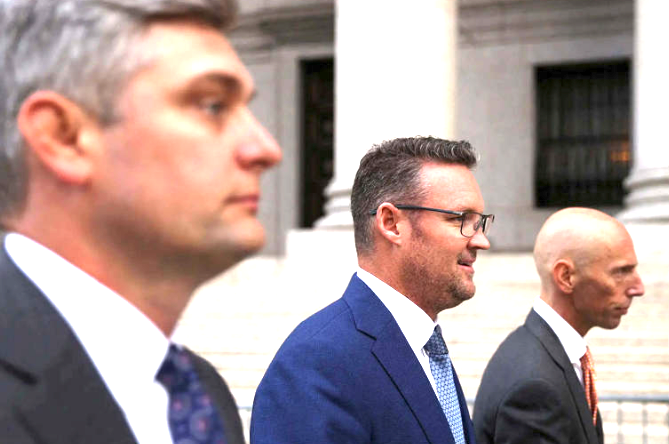 Тревор Милтон (в середине) направляется на рассмотрение заявки о банкростстве в компании своих адвокатов