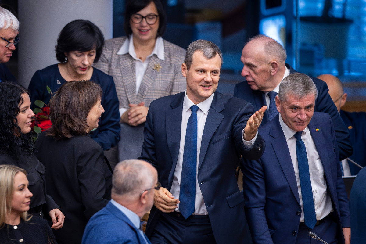 Lithuania's Social Democratic party member Gintautas Paluckas, center, smiles at the parliament after Lithuania's parliament approved Paluckas as the new Lithuania's Prime Minister, in Vilnius, Lithuania, Thursday, Nov. 21, 2024. (AP Photo/Mindaugas Kulbis)
