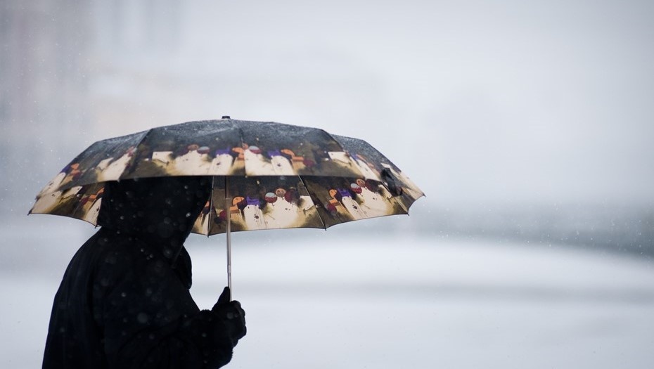    Житель Петербурга прячется под зонтом во время плохой погоды Автор фото: Александр Кулыгин / "Деловой Петебург"