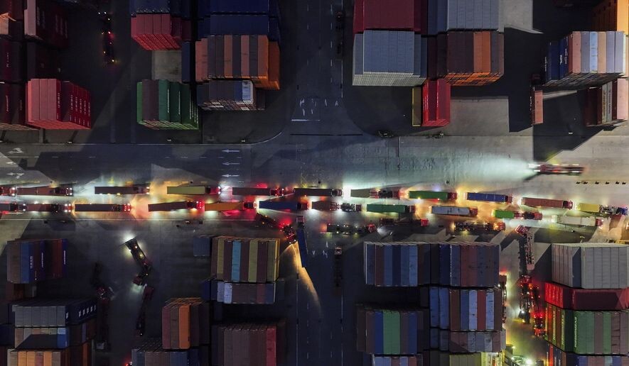 Во вторник, 8 апреля 2025 года, грузовики выстраиваются в очередь, чтобы выехать с контейнерного терминала в Нанкине, провинция Цзянсу, Восточный Китай. (Chinatopix через AP)