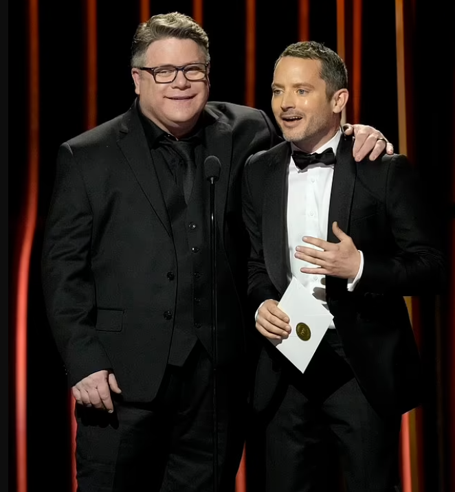 Темные тона и одежда по размеру: советы для корпулентной и невысокой фигуры во многом схожи. Шон Эстин в мешковатом костюме с чрезмерно длинными рукавами и Элайджа Вуд в прекрасно сидящем смокинге на вручении премии Гильдии киноактеров США​​, 2024.