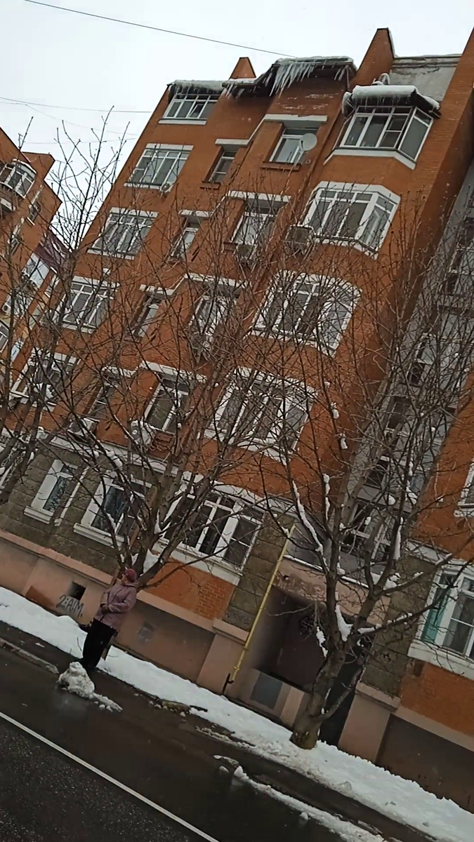 Стоит женщина, а прямо над ней висит огромный сосуль - просто ужас, если представишь, что может произойти