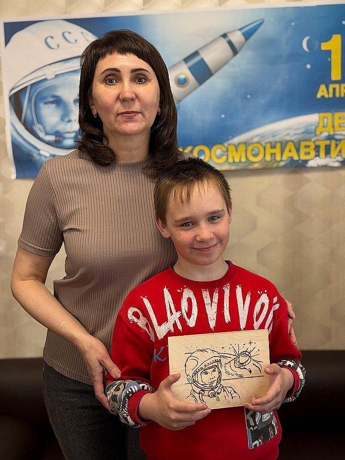 Заречнева Лариса Павловна и мальчик, держащий в руках выжженый им рисунок космонавта