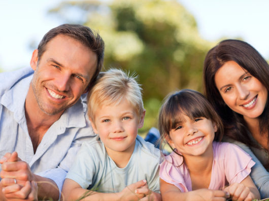    Семья отдыхает на траве в парке //Фото iStock / Goodboy Picture Company