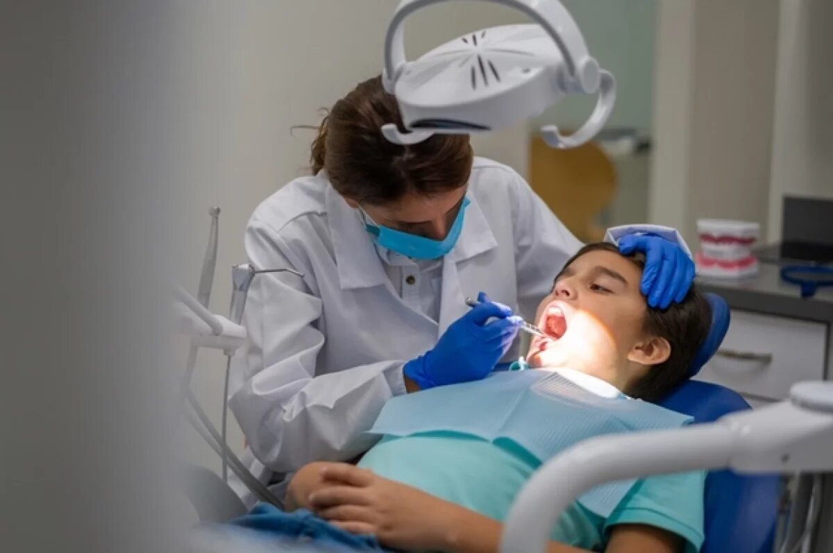    Подросток на осмотре у стоматолога.