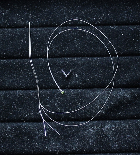 Отрезаем нитку 2 длины изделия + 10-15см. Надеваем на нить одну бисеринку. Складываем нить пополам, и два конца вдеваем в иголку. Бисеринка может быть любая, не обязательно та, что используется при сборке браслета. По размеру она должна входить в скуфейку.