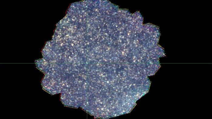 Итоговая карта тёмного поля SPIRE, созданная путём объединения синего (250 микрометров), зелёного (350 микрометров) и красного (500 микрометров) каналов камеры SPIRE. Каждый канал состоит из 141 отдельного изображения, наложенных друг на друга. Пятна на изображении — это отдельные галактики или группы галактик. Однако изображение настолько переполнено, что на нём почти нет свободного места, а самые тусклые галактики сливаются с фоновым светом на карте.