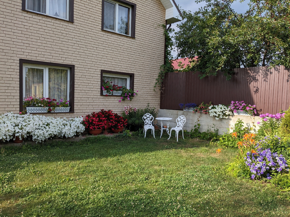 Ящики с цветами на заборе в июле