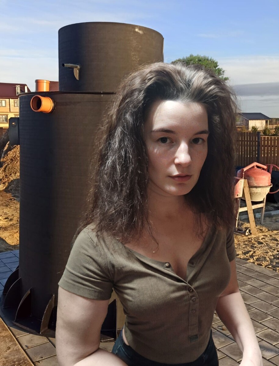 Девушка на фоне вертикального септика с якорем (грунтозацепом)