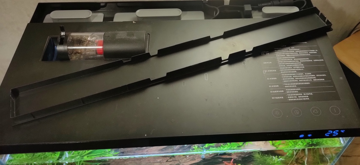 Вид аквариума сверху, со снятой крышкой блока фильтров, слева автмотическая кормушка