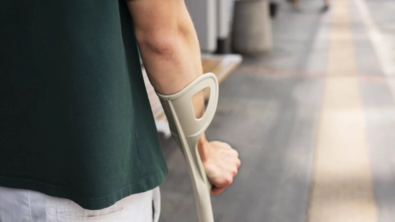     Мужчина с костылём идёт по городу. Фото: ru.freepik.com, автор freepik.