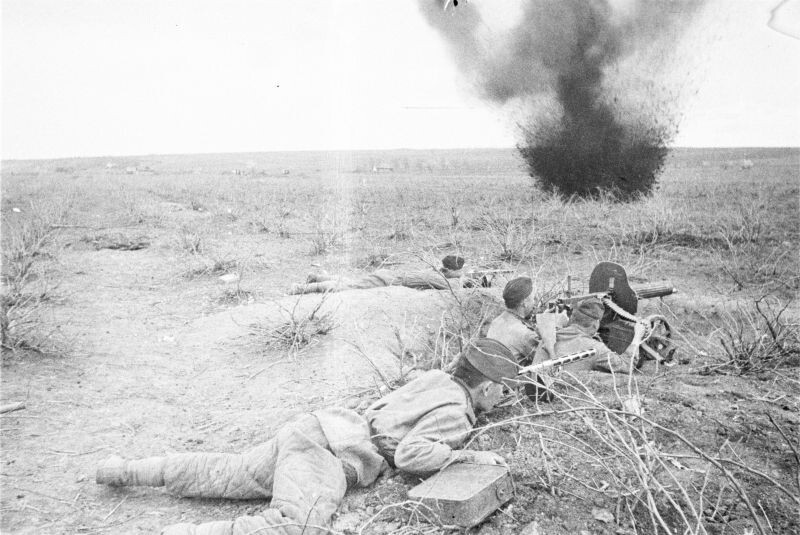 Красноармейцы в бою. Боец на переднем плане тащит расчету пулемета «Максим» коробку с пулеметными лентами. Фото Якова Рюмкина