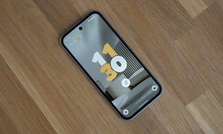 Спереди 9a выглядит точно так же, как обычный Pixel 9, с оптическим сканером отпечатков пальцев под экраном и функцией распознавания лиц для разблокировки телефона и приложений. Фото: Сэмюэл Гиббс/The GuardianПросмотр изображения в полноэкранном режиме