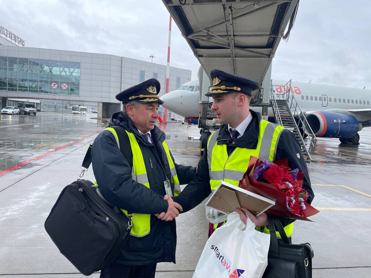 Пилот-инструктор В.А. Комаров (слева) поздравляет сына Артема с выполнением первого самостоятельного полета в качестве КВС Боинг 737NG. Аэропорт "Пулково", 12 апреля 2025 года. Фото: пресс-служба авиакомпании Smartavia