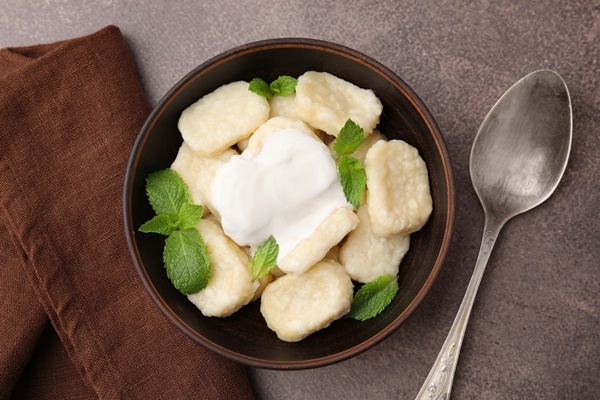 Когда всплывут наверх, вынуть также дуршлагом, уложить на блюдо, облить маслом, сметаной и подавать.
