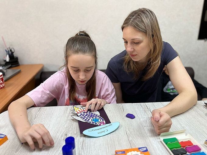 Мама помогает дочери создавать аппликацию