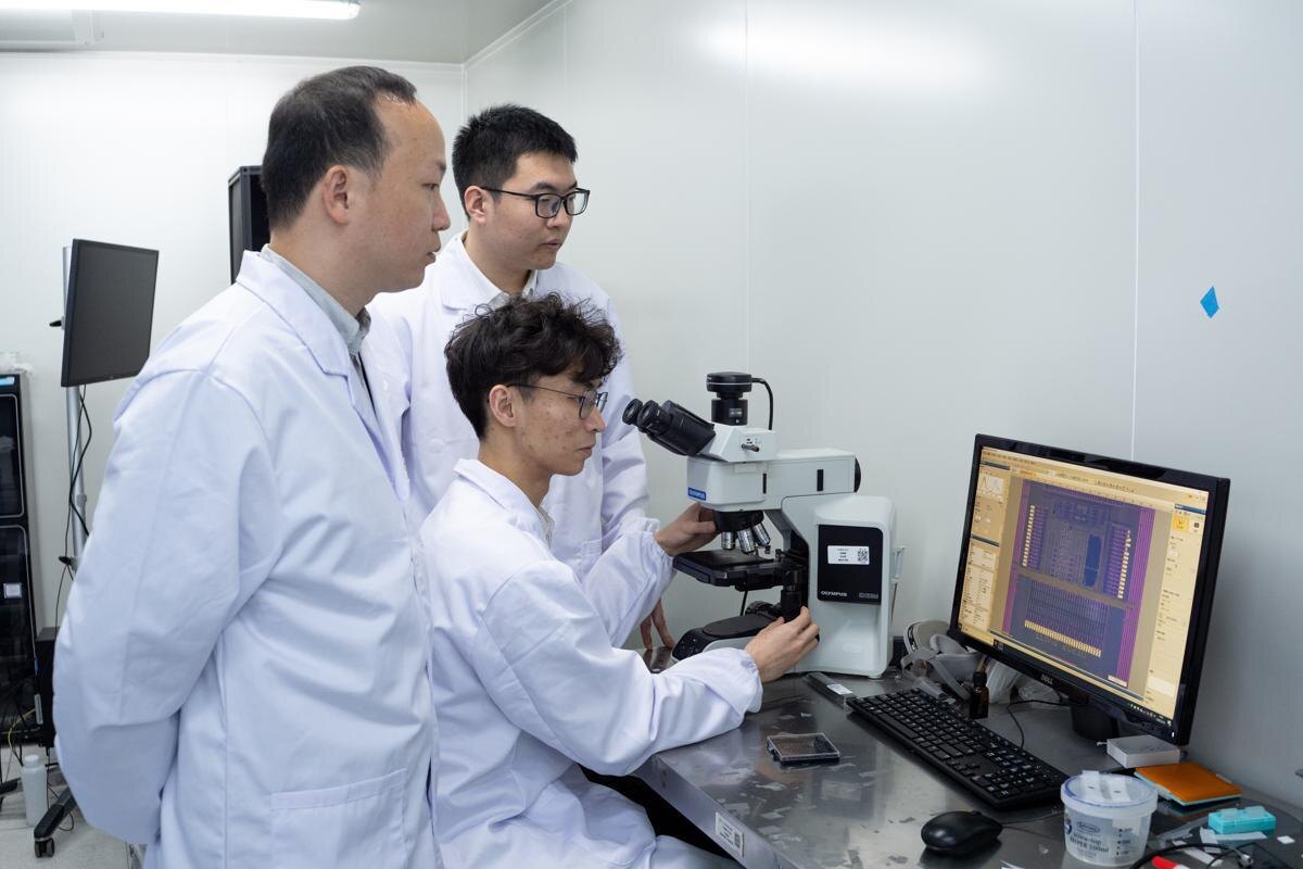 Исследователи из шанхайского Университета Фудань, разработавшие устройство флэш-памяти пикосекундного уровня, работают в своей лаборатории. [Фото: Гао Эрцян/chinadaily.com.cn]