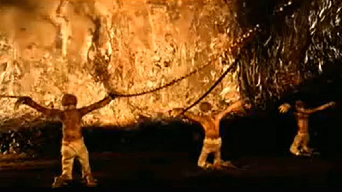 Люди внутри пещеры сидят прикованными цепями лицом к стене