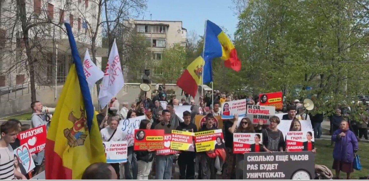 группа людей с криками и плакатами у здания суда