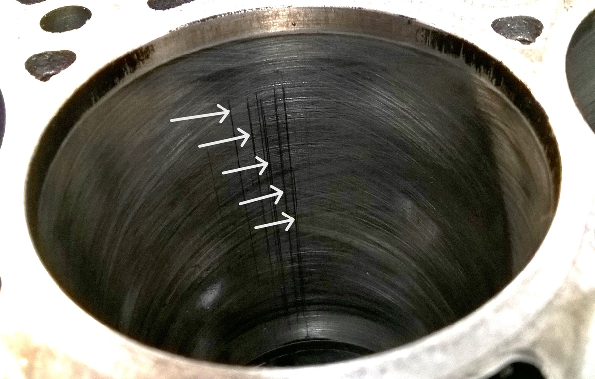 Фото 1. Вертикальные царапины на рабочей поверхности цилиндра показаны стрелками.