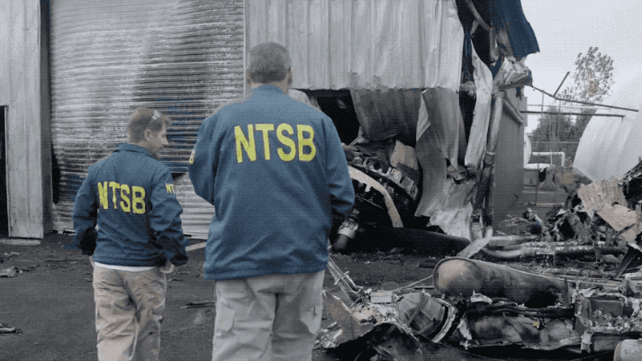Следователи NTSB изучают двигатель номер четыре, который частично врезался в здание. (NTSB)