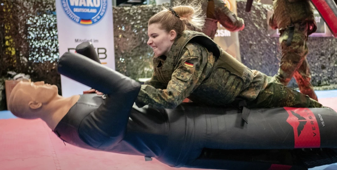 И на нём: посетительница выставки пробует свои силы в ближнем бою на курсах Бундесвера в Fibo © Франк Рёт (Frank Röth)