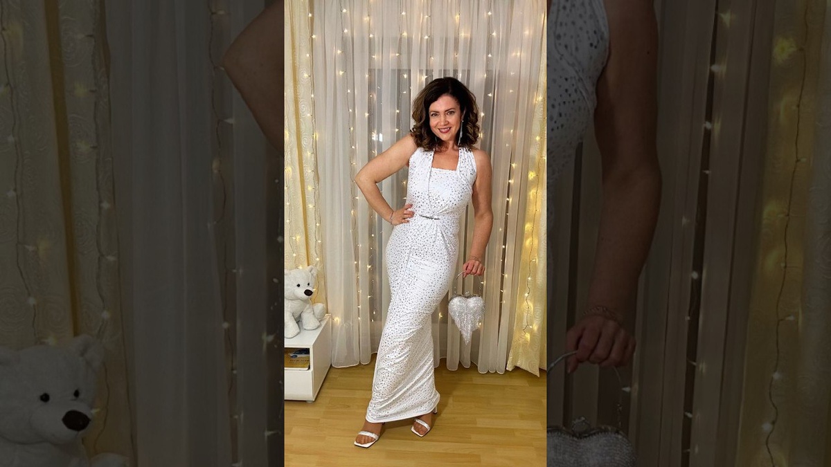 Современная классика: стиль и уверенность в каждом шагеНа этой фотографии женщина демонстрирует идеальное сочетание элегантности и уверенности. Её платье в теплых коричневых тонах с асимметричной драпировкой подчёркивает фигуру и добавляет динамики образу. Глубокий разрез на ноге придаёт наряду нотку дерзости и подчёркивает стройность силуэта.Простая, но изысканная укладка и макияж идеально гармонируют с общим образом. Туфли на каблуке завершают этот стильный лук, добавляя утончённости и грации.Обстановка вокруг — деревянные элементы декора, растения и декоративные фигурки — создают уютную, почти этническую атмосферу, подчёркивающую природную гармонию образа.Это — образ уверенной в себе женщины, которая не боится выделяться и знает, как подчеркнуть свою индивидуальность через стиль.