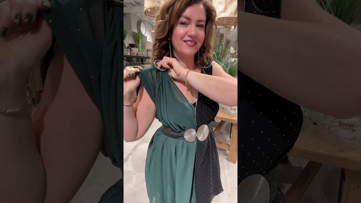 Сияние и элегантность в гармонииНа этом фото — сочетание изящества и современной красоты. Женщина запечатлена в изумрудно-зелёном платье с пайетками, открывающем одно плечо. Дизайн платья подчёркивает фигуру, а драпировка в верхней части и декоративный цветок на плече придают образу утончённость.Её волосы уложены мягкими волнами, а длинные серьги и браслеты прекрасно дополняют наряд. Фон с нежными огоньками и шторами создаёт атмосферу уюта и праздничности.Этот образ — яркое воплощение элегантности, уверенности и современной женственности. Каждая деталь уникальна, каждая улыбка — отражение красоты.