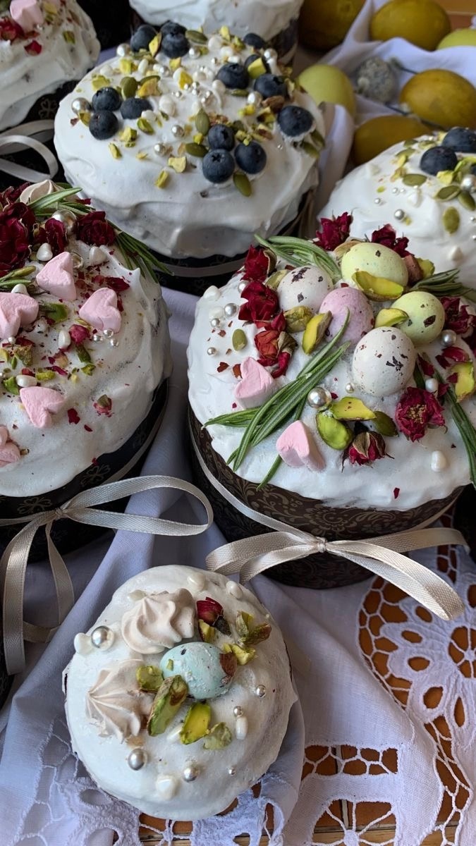 Пасхальные куличи, украшенные глазурью, голубикой, фисташками, серебряными бусинами и сухоцветами
