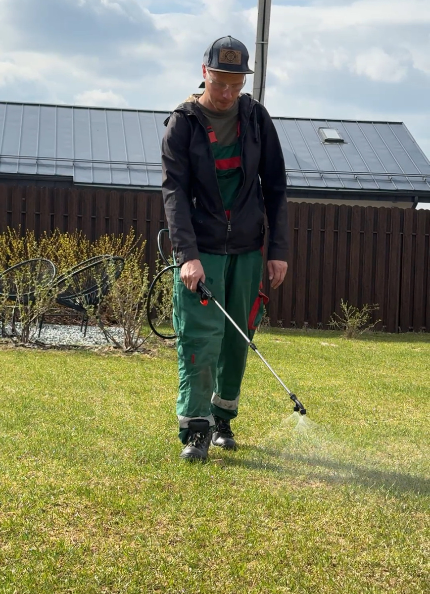 Рюкзак с раствором за спиной, в руках - распылитель