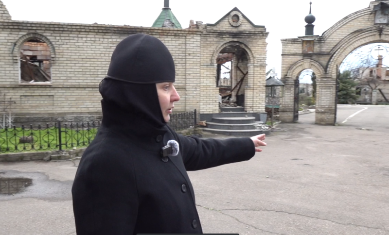    Матушка Анна показывает место гибели своей мамы. Прилёт украинского снаряда унёс жизнь родного человека 13 мая 2022 года. Фото: Царьград