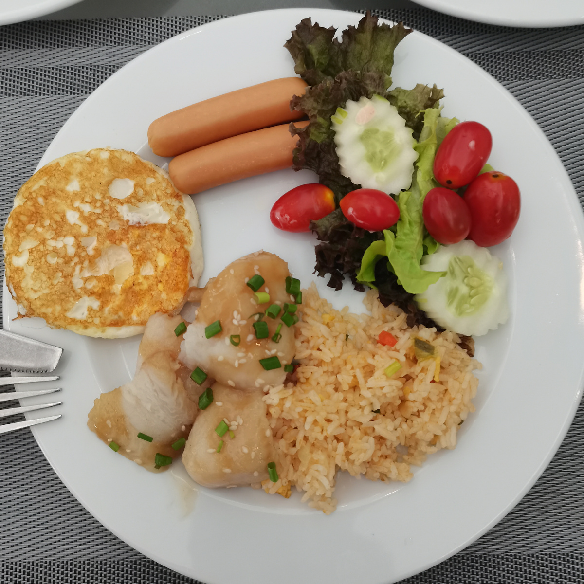 Мой завтрак. Яйцо, 3 кусочка рыбы, 2 свиные сосиски, жареный рис с овощами и яйцом, овощи. Овощей надо бы побольше, явно не половина тарелки. Недочёт, однако. 