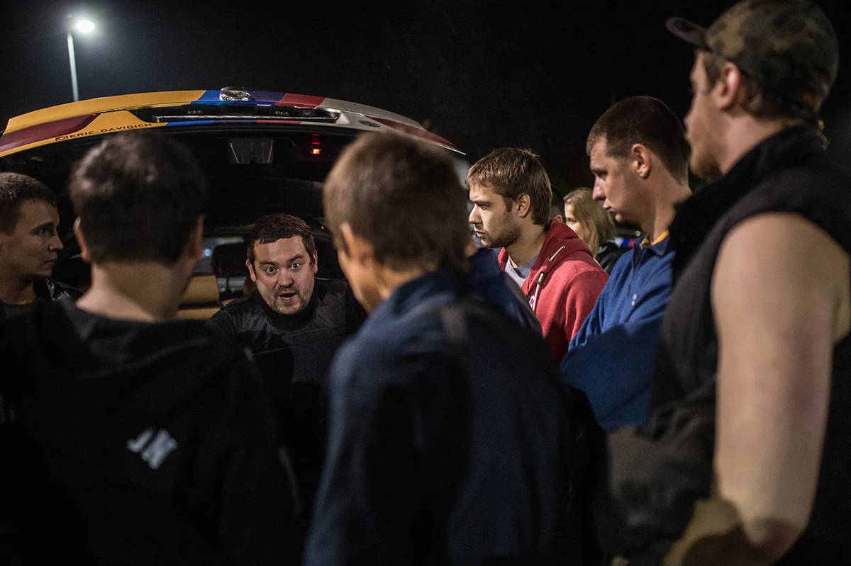 Организатор рейдов стритрейсеров Эрик «Давидыч» Китуашвили (третий слева) проводит инструктаж участников патруля, 13 сентября 2014 года