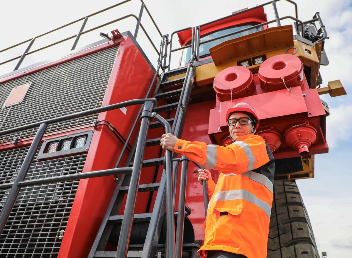 Водитель нового китайского самосвала уже оценил преимущества техники, в том числе удобные лестницы для подъёма на борт.