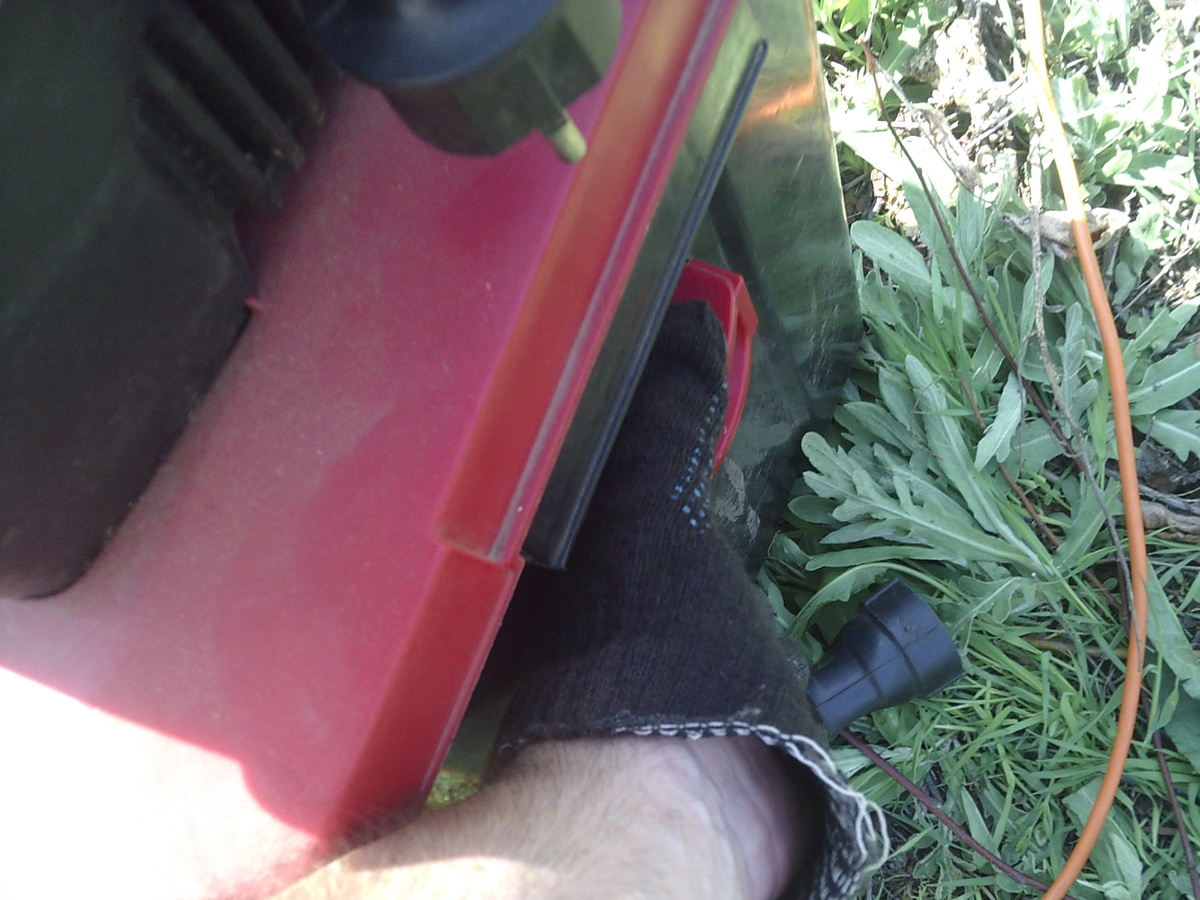 Сначала необходимо переместить вниз красную ручку замка накопителя (при этом также размыкается цепь электропитания, что предотвращает включение прибора со снятым накопителем)