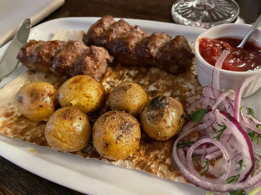 Шашлык в Gayane’s подают в традиционной армянской сервировке: с картофелем, луком, овощами, лавашом и соусом. Фото: Risha / Яндекс Карты